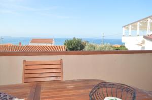 uma varanda com uma mesa e cadeiras e o oceano em Casa del Cisto em S'archittu Cuglieri