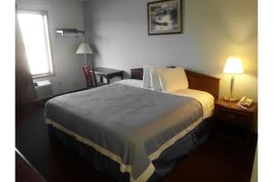 a hotel room with a bed and a table with a lamp at Columbus Motel in Columbus Junction