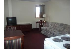 a living room with a couch and a kitchen with a stove at Columbus Motel in Columbus Junction