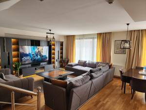 a living room with a couch and a tv at TAKSiM PERFECT RESiDENCE, 3 BEDROOMS, 140 M2, POOL GYM SAUNA ACCESS in Istanbul