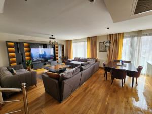 a living room with a couch and a table at TAKSiM PERFECT RESiDENCE, 3 BEDROOMS, 140 M2, POOL GYM SAUNA ACCESS in Istanbul