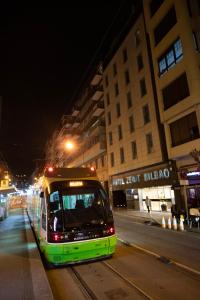 a bus is parked on a city street at night at Hotel Zenit Bilbao in Bilbao