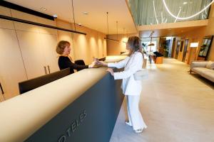 Hotel Zenit Bilbao في بلباو: سيدتان واقفتان في مكتب في صالون