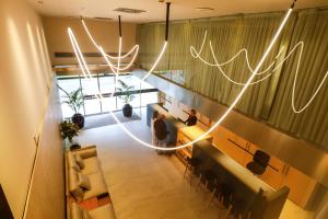 a lobby with people sitting in a room with lights at Hotel Zenit Bilbao in Bilbao