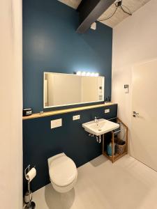a bathroom with a white toilet and a sink at Guestroom by "FARBGESTALT" in Sarstedt