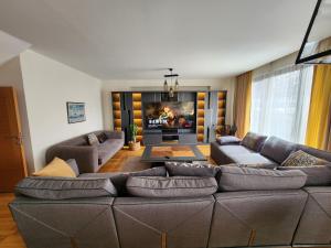 ein Wohnzimmer mit einem großen Sofa und einem TV in der Unterkunft TAKSiM PERFECT RESiDENCE, 3 BEDROOMS, 140 M2, POOL GYM SAUNA ACCESS in Istanbul