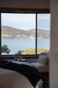 a room with a large window with a view of a lake at Sea View Guest House in Hobart