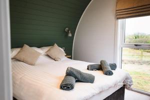 1 cama con 2 toallas y ventana en Fallow Lodge, en Little Bytham