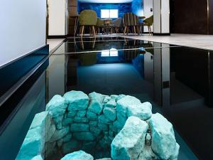 una camera con piscina d'acqua con tavolo e sedie di ibis Styles Chaves a Chaves