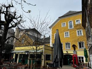 un edificio giallo con un ombrello davanti di Hotel Gösser Bräu a Wels