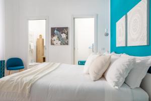 a bedroom with a large white bed with blue walls at Parisi apt in Rome