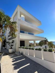 een wit gebouw met planten aan de zijkant bij GALA'Pe in Zadar