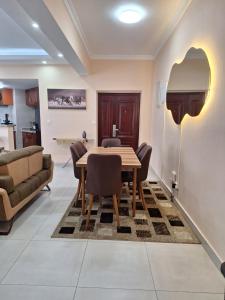 a dining room with a table and a couch at Sabra Palmvillage mikocheni in Dar es Salaam