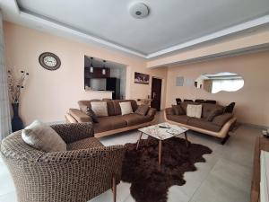 a living room with two couches and a table at Sabra Palmvillage mikocheni in Dar es Salaam