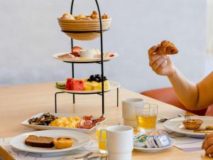 a table with a tray of breakfast food on a table at Mercure Fátima in Fátima