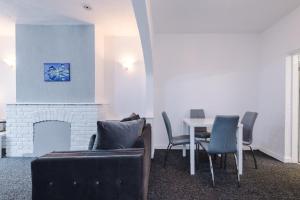 een woonkamer met een bank en een tafel met stoelen bij 2 Bedroom | Central location in Saint Helens