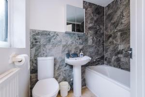 een badkamer met een toilet, een wastafel en een bad bij 2 Bedroom | Central location in Saint Helens