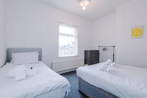 two beds in a room with white walls at 2 Bedroom | Central location in Saint Helens