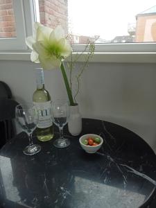 a table with two wine glasses and a flower in a vase at Pension Schier in Zandvoort