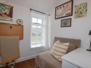 a living room with a couch and a window at Waterside Cottage in Truro