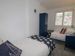 a bedroom with two beds and a window at 2 The Stables in Dartmouth
