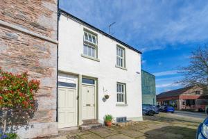 a white brick house with a white garage at 40 The Gill - Ulverston Town Centre in Ulverston