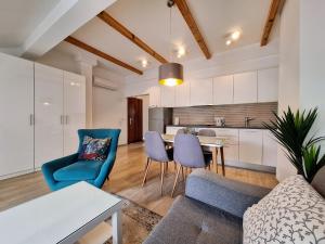 een woonkamer met een bank, stoelen en een tafel bij City Center apartments in Mostar
