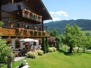 a building with a balcony with flowers on it at Schranbachhof in Maria Alm am Steinernen Meer