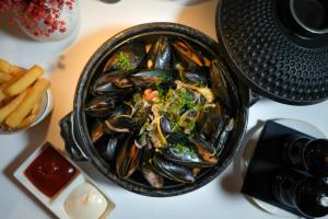 un bol de moules et de salade à côté d'une assiette de frites dans l'établissement Ritz Carlton Residences DIFC Downtown Dubai, à Dubaï