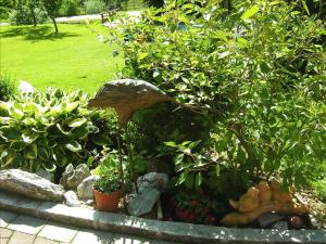 a garden with plants and rocks and a tree at Schranbachhof in Maria Alm am Steinernen Meer