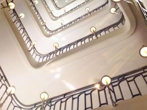 Una escalera de caracol blanca con luces. en Hôtel Le Royal Monceau Raffles Paris, en París