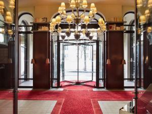 een lobby met een kroonluchter in een gebouw bij Hôtel Le Royal Monceau Raffles Paris in Parijs