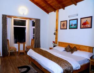 um quarto com uma cama grande e uma janela em Aaryam villa em Mukteshwar