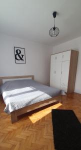 a bedroom with a bed and a wooden floor at Mieszkanie w domu jednorodzinnym in Człuchów