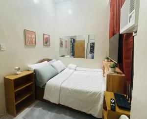 een kleine slaapkamer met een bed en een spiegel bij Cozy 1BR Unit with Full Bathroom,Kitchen, Wifi at Sonia's Island Stay in Virac