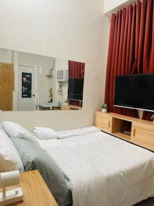 um quarto com uma cama grande e uma televisão de ecrã plano em Cozy 1BR Unit with Full Bathroom,Kitchen, Wifi at Sonia's Island Stay em Virac