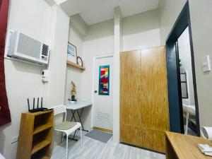 ビラクにあるCozy 1BR Unit with Full Bathroom,Kitchen, Wifi at Sonia's Island Stayのドア、テーブル、デスクが備わる客室です。