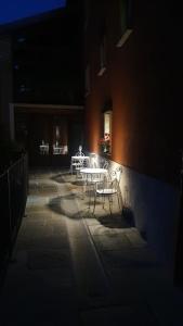 eine Terrasse mit einem Tisch und Stühlen in der Nacht in der Unterkunft Il Sulé in Giaveno