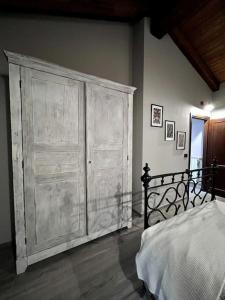 ein Schlafzimmer mit einem großen Holzschrank neben einem Bett in der Unterkunft Il Sulé in Giaveno