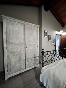 a bedroom with a large wooden cabinet next to a bed at Il Sulé in Giaveno