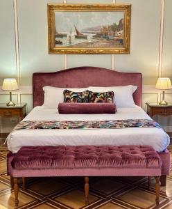 a bedroom with a large bed with a painting on the wall at Palazzo Monga Boutique Guesthouse in Verona