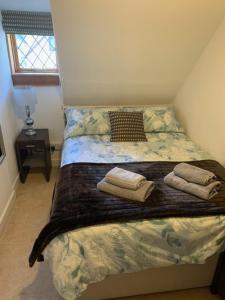 a bedroom with a bed with two towels on it at Eilean View in Lamlash