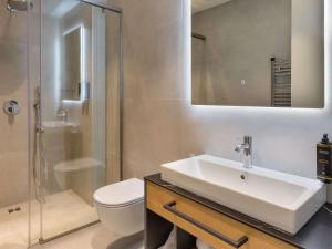 ein Bad mit einem Waschbecken, einem WC und einer Dusche in der Unterkunft Mercure Tirana in Tirana