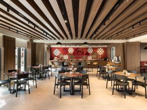a restaurant with wooden ceilings and tables and chairs at Mercure Tirana in Tirana