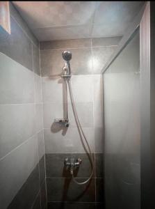 a shower with a hose in a bathroom at Rum Roza luxury camp in Wadi Rum