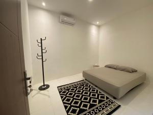 a white bedroom with a bed and a rug at Sare Living Homestay in Yogyakarta