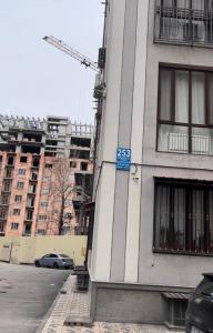 un bâtiment avec un panneau bleu sur son côté dans l'établissement 253 ул.Паркентская Ташкент, à Yalanghoch