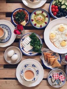 uma mesa de madeira com pratos de comida para o pequeno-almoço em Rum Roza luxury camp em Wadi Rum