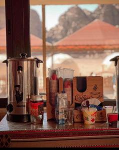 un piano di lavoro con macchinetta del caffè e altri articoli di Rum Roza luxury camp a Wadi Rum