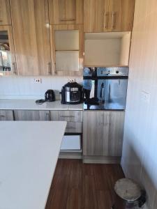 a kitchen with wooden cabinets and a counter top at Inviting 3-Bed House in Bulawayo in Bulawayo